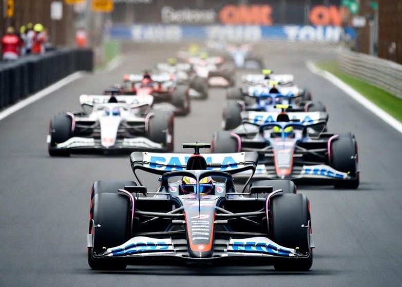 Formula 1 cars racing under stadium lights